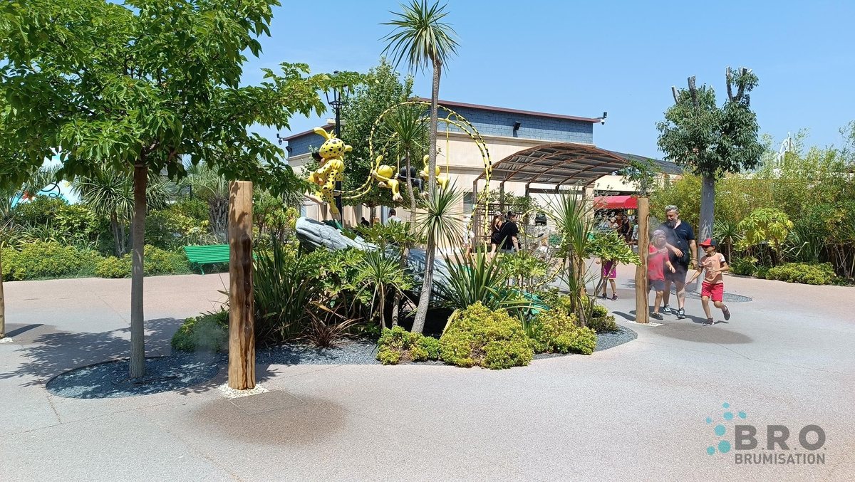 Mât brumisateur en bois BRO au milieu d'un massif planté, sur une place