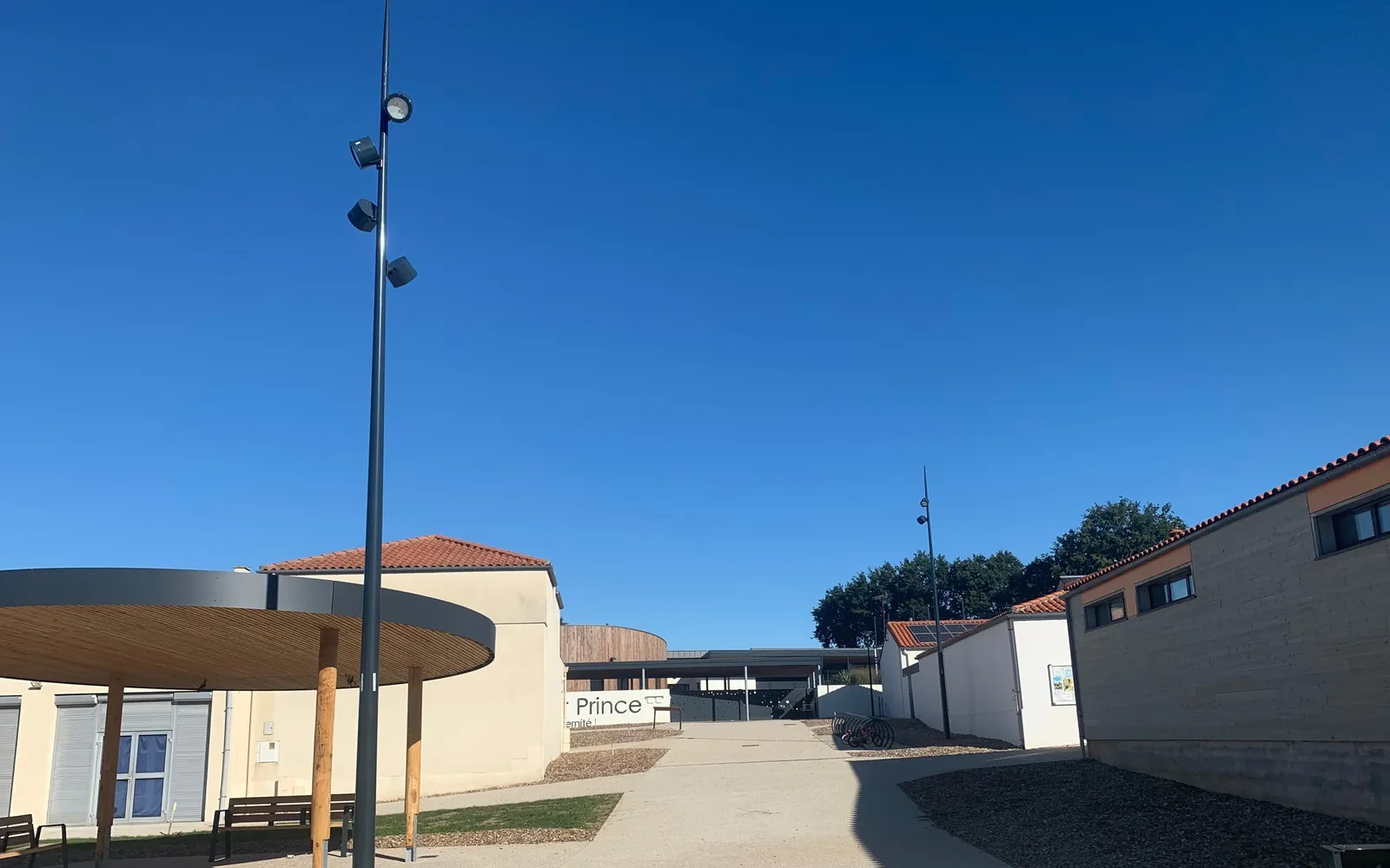Mât grappe IRYS à projecteurs multiples devant les bâtiments scolaires de Beaurepaire, ciel bleu