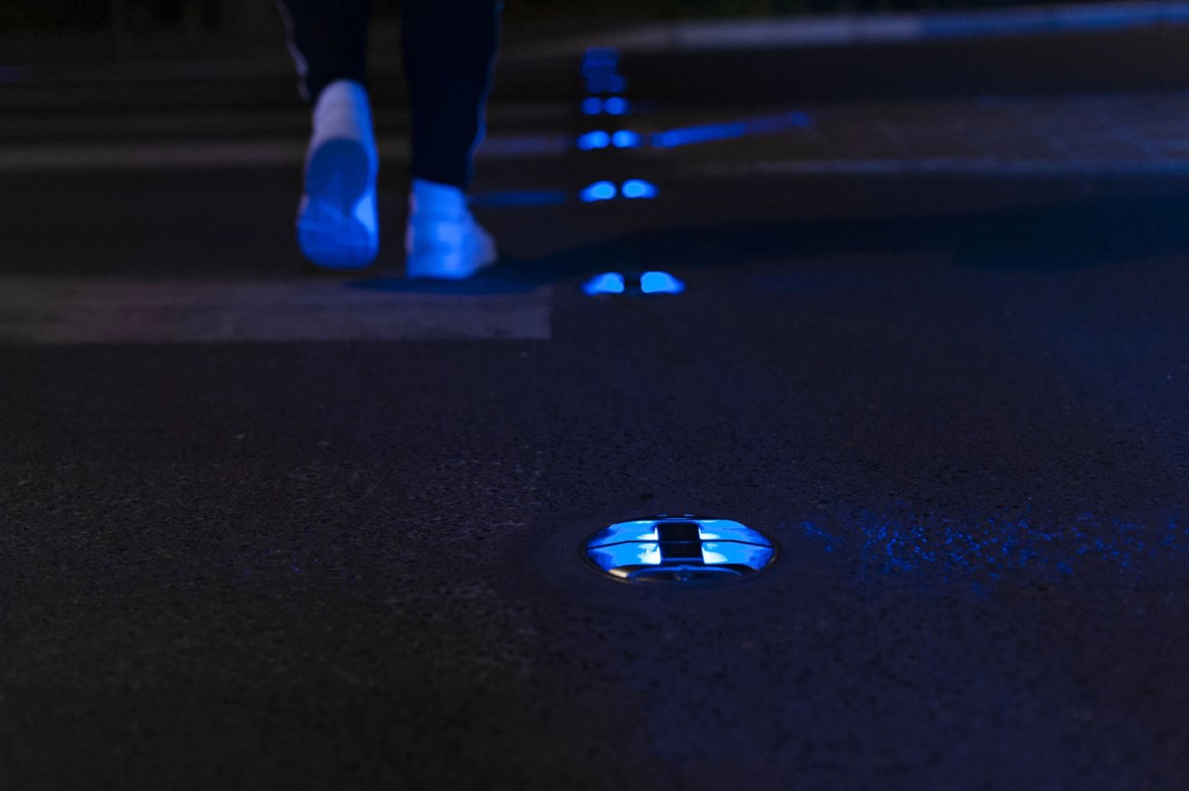 Plot lumineux Eco-Innov encastré dans la chaussée, éclairant en bleu au passage d'un piéton