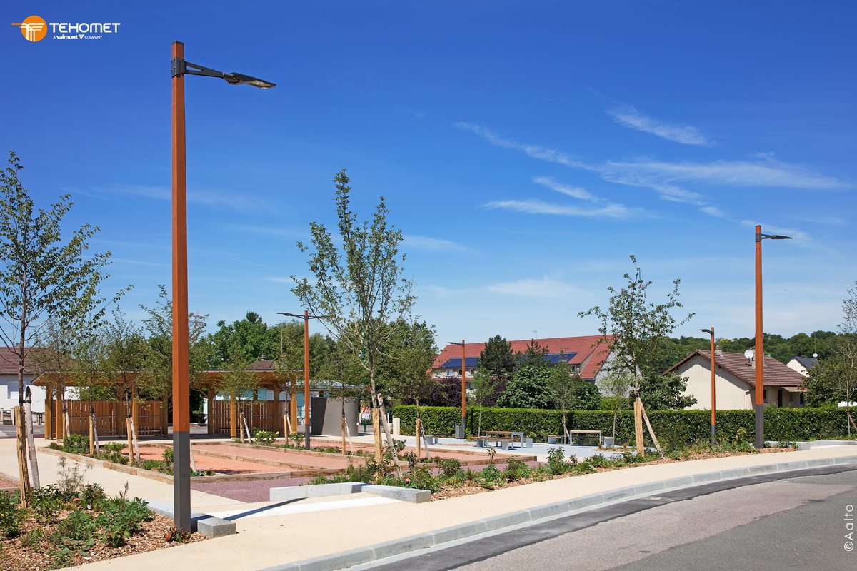 Mâts bois Koli de Tehomet (groupe Valmont) sur une place de village avec pergola et bancs