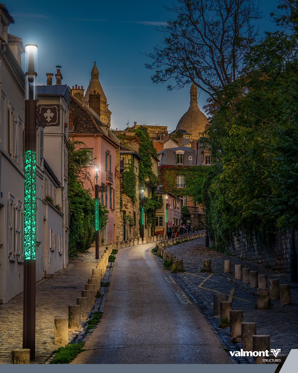 Mâts Smart Jalousie de Valmont avec motifs lumineux verts dans une rue pavée de Montmartre